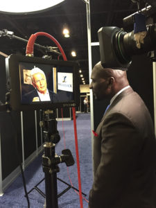 Solomon Wilcots watches segment taping of Harry Reveles at NASS